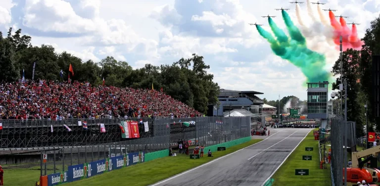 Autodromo Nazionale Monza Zuschauertribüne mit italienischen Fahnen und buntem Rauch über dem Rennstreckenkurs.